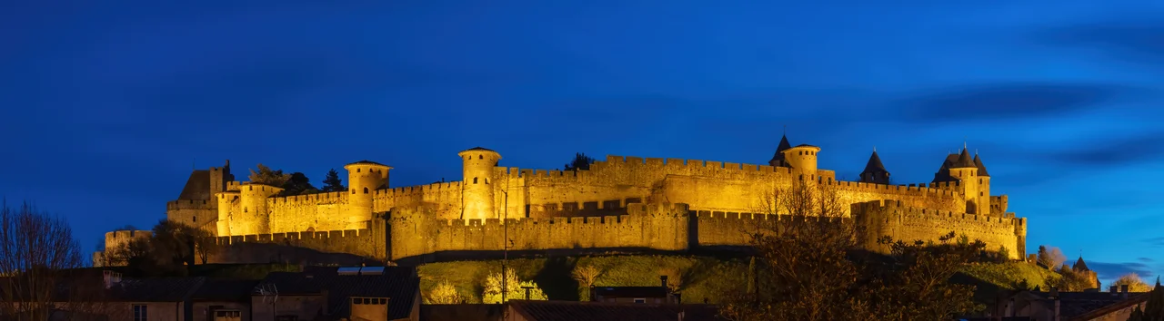 Fortified city of Carcassonne during the blue hour, France. Founded during the Gallo-Roman period, the citadel derives its reputation from its 3 kilometres (1.9 mi) long double surrounding walls interspersed by 52 towers. The medieval citadel, situated on a hill on the right bank of the river Aude, was restored at the end of the 19th century by the theorist and architect Eugène Viollet-le-Duc. In 1997, it was added to the UNESCO list of World Heritage Sites because of its exceptional testimony to the architecture and planning of a medieval fortress town.